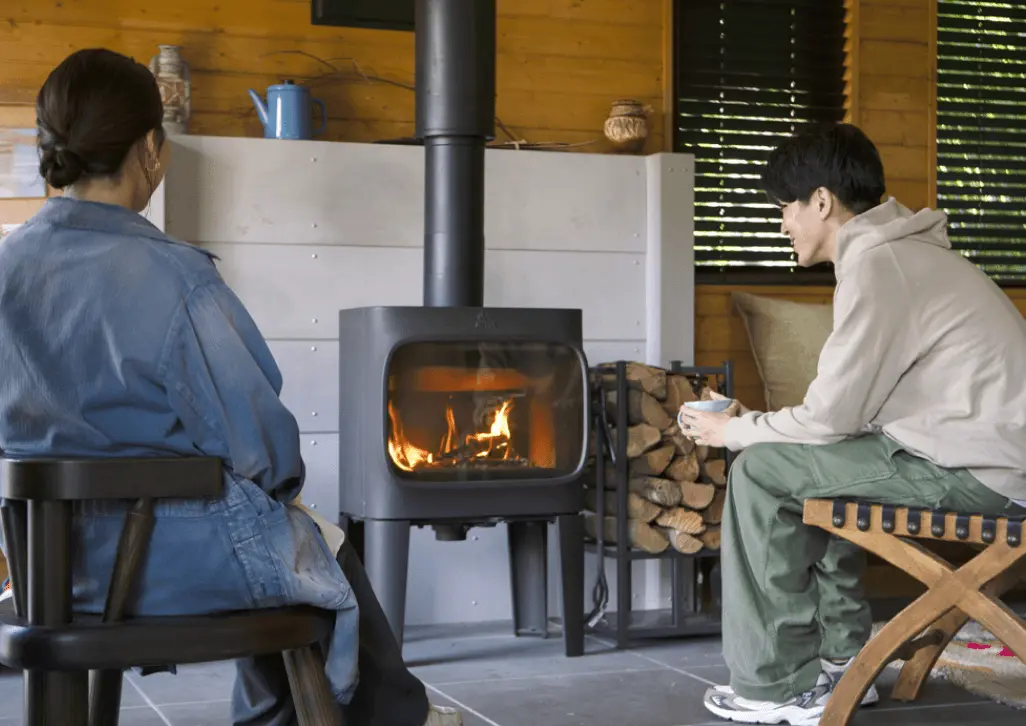 薪ストーブで暖まる体験者の画像